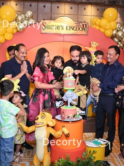The cake-cutting ceremony is a highlight of the party. Here, the family gathers around a themed cake, surrounded by the beautiful Lion King decor.