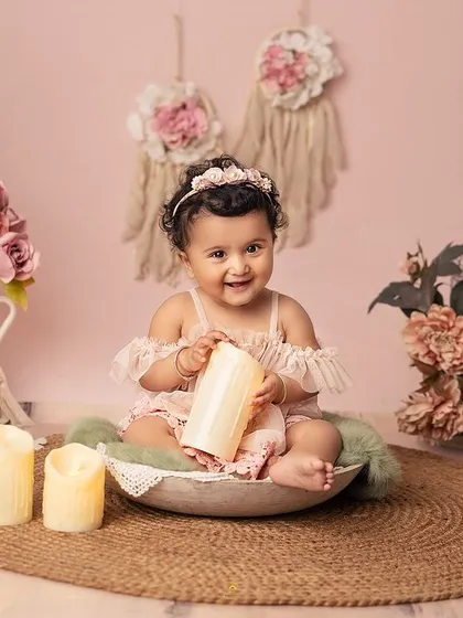After the cake, we capture these sweet, simple moments. Here, she is sitting in a rustic bowl, surrounded by the soft, dreamy elements of her boho birthday setup.