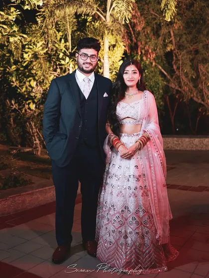 A classic outdoor portrait of a couple at their engagement, dressed in elegant evening wear.