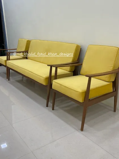 Side profile of the yellow mid-century sofa and armchair.