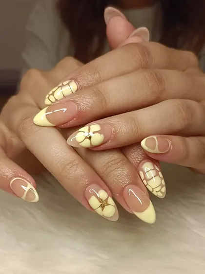 A full view of the butter yellow manicure with 3D flowers and croc-print art.