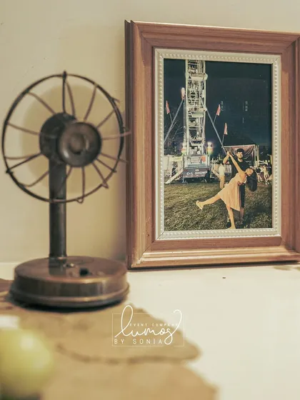 A charming detail from an engagement party, with a vintage fan and a framed photo of the couple.