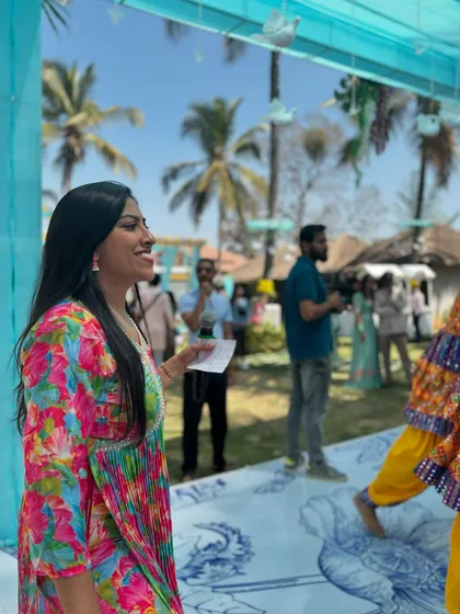 In my element, hosting an outdoor Mehendi ceremony. With cue cards in hand, I guide the flow of events, making sure performances and rituals run smoothly while keeping the guests entertained.