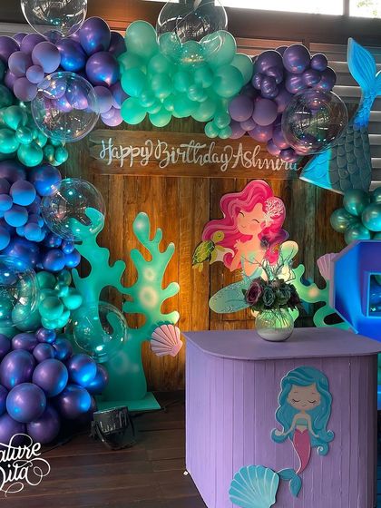 The main photo backdrop for the mermaid party, featuring a stunning balloon arch in ocean colours, mermaid cutouts, and a light-up number '8'.