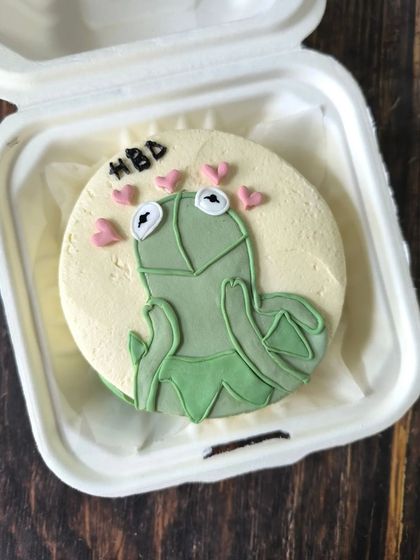 Your favorite memes can become the centerpiece of your celebration. This bento cake features Kermit the Frog, hand-piped with buttercream for a fun and recognizable design.