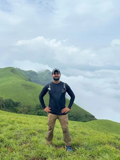 A trekker standing proudly above a sea of clouds on the Bandaje trail. The feeling of being on top of the world is unmatched.