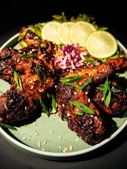Our U-Morok Chicken Wings, glazed in a fiery, house-made sauce. The star ingredient is the U-Morok, or King Chilli, from Northeast India, which gives these wings a unique smoky heat. They are garnished with fresh spring onions, sesame seeds, and served with lime to balance the spice.
