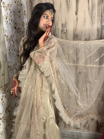 A candid shot of a happy bride, her joy shining through. The soft, flowing dupatta and elegant hairstyle create a dreamy, ethereal look.