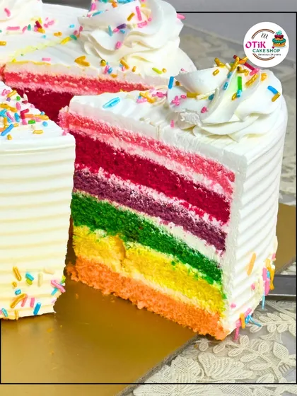 A slice of pure joy. Our Rainbow Cake features vibrant, soft layers of sponge with delicate cream cheese frosting in between, showing the fun and precision we put into our celebration cakes. It's a favorite for birthdays and happy occasions.