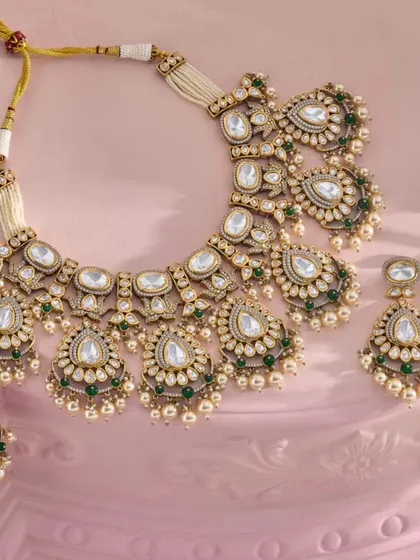 A classic Polki necklace set with green bead drops, a versatile piece that complements many bridal outfits.