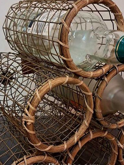 A close-up of our six-bottle wine stand, showing how securely it holds standard wine or liquor bottles. The natural cane material adds a rustic charm to your bar setup.