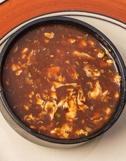 A classic Indo-Chinese favorite, our Manchow Soup is a spicy and savory dark broth filled with vegetables and topped with crispy fried noodles for a satisfying crunch.