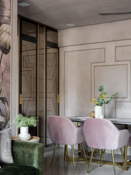 A dining area from our award-winning 'Maison-De-Confort' project. The space combines a dramatic wallpaper with soft, blush-pink velvet chairs for a look that is both bold and inviting.