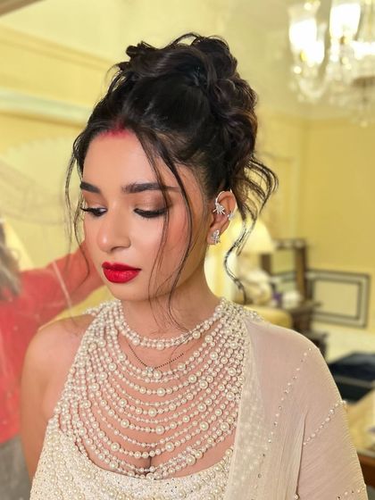 A modern take on the bridal updo with a high, tousled bun. This style is perfect for a reception, offering a chic and fashionable look.