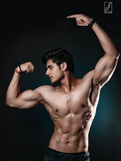 A dynamic pose that combines a bicep flex with an upward gesture, drawing the eye across the entire upper body. It highlights the serratus anterior and oblique muscles, key details for a contest-ready physique.