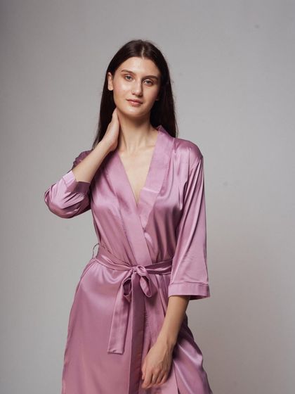 A three-quarter portrait that feels soft and inviting. This shot highlights the texture of the satin fabric and the robe's comfortable fit.
