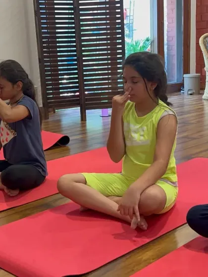 Children practicing pranayama, or mindful breathing. These techniques help reduce stress and improve focus from a young age.
