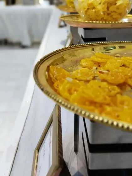 A close-up of our crispy, syrup-soaked jalebis, garnished with nuts. We ensure every dish, even a traditional sweet, is prepared and presented with care.