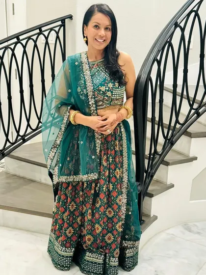 This client is ready for a celebration in a gorgeous teal lehenga with intricate patterns. She has accessorized it beautifully with simple gold bangles and earrings, letting the outfit shine.