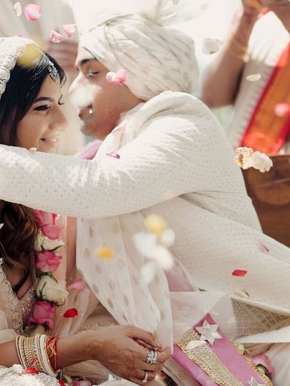 Showered in petals, the couple shares an intimate moment. This close-up shot is full of love, texture, and emotion, capturing the magic of the celebration.