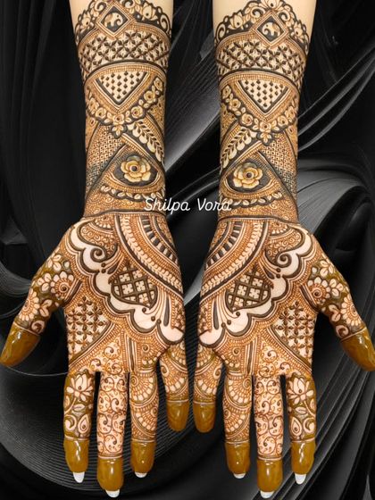 A very dense and intricate design covering the full hands and wrists, perfect for a grand Karwa Chauth celebration.