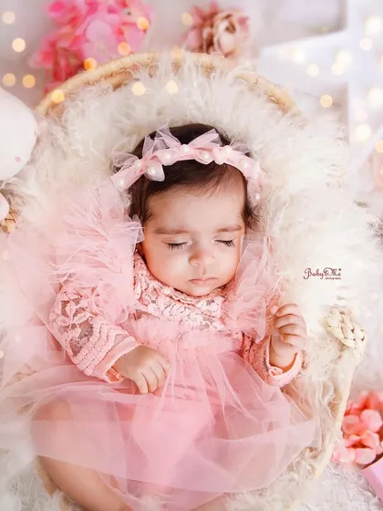 Dressed in a delicate pink tulle dress, this little princess is sleeping peacefully. The soft lighting and dreamy props create a truly magical atmosphere.