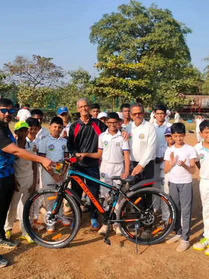 Awarding Parth Rane the 'Player of the Year 2023' cycle, surrounded by his happy teammates.