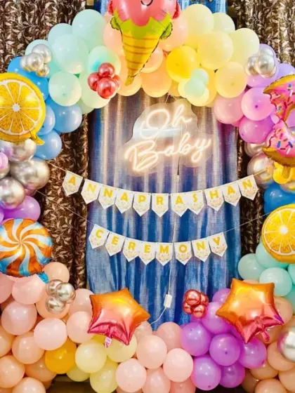 A fun and sweet 'Oh Baby' Annaprasan ceremony decoration with a candy-land theme, featuring donut and ice cream foil balloons.
