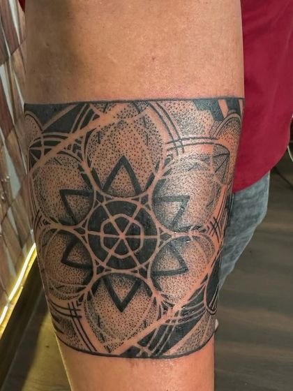 A geometric armband featuring a Star of David pattern with dot work shading. This is a modern and spiritual design.