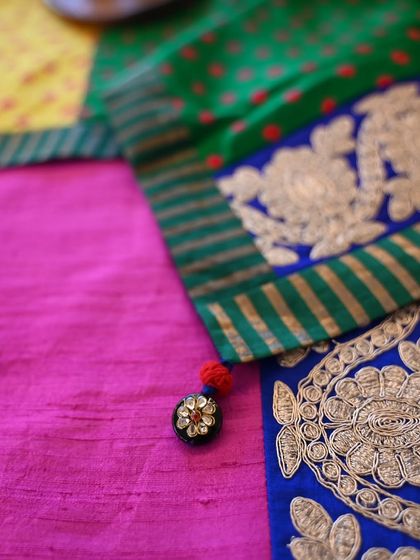A close-up of the tablecloth's corner, showing the detailed brocade border and a small, handmade tassel for a finishing touch.