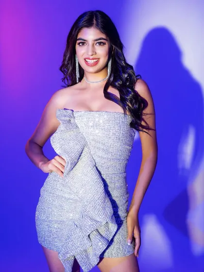 A happy and confident pose in the silver party dress. The makeup features a pop of red on the lips, adding a classic touch to the glamorous look.
