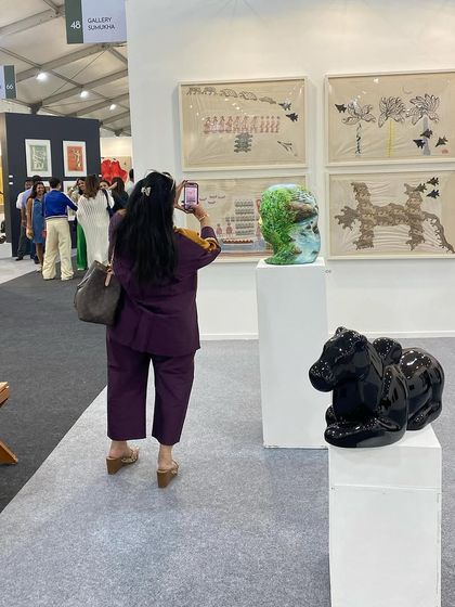A visitor photographing the sculptures at our booth.