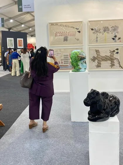 A visitor photographing the sculptures on display.