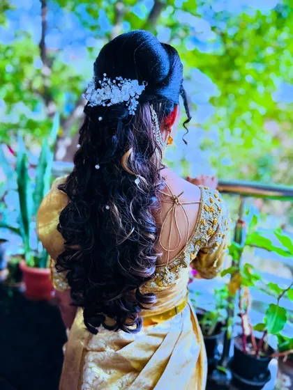 A beautiful reception hairstyle for my bride Chitra. This look combines soft curls and a half-updo with delicate floral accessories, perfect for a modern yet elegant bridal style.