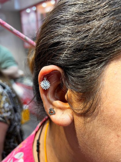 A simple yet stunning snowflake hanging in the helix, paired with a small tragus stud.