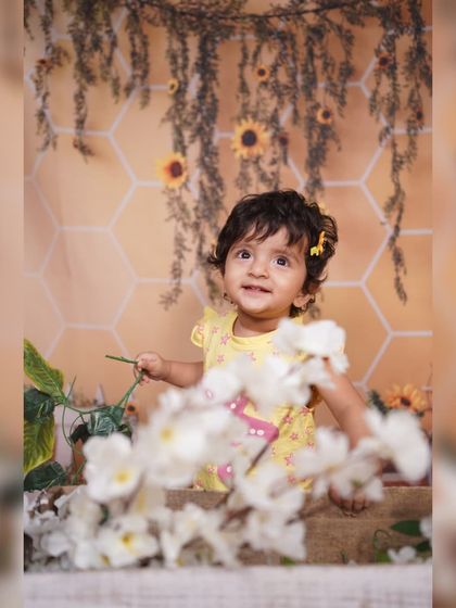 Peeking through the flowers. I use foreground elements like these white blossoms to add depth and a touch of artistry to my baby portraits.