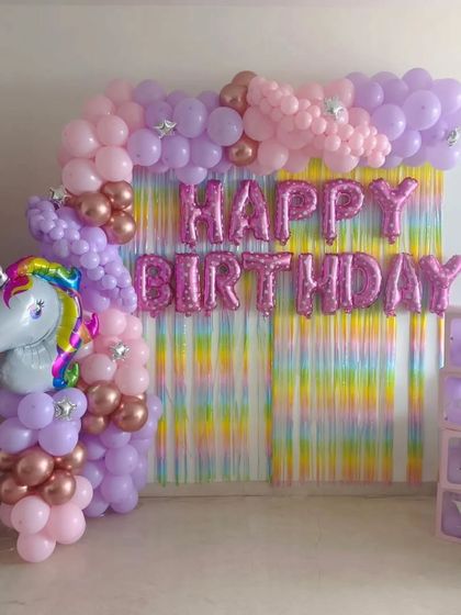 A simple yet beautiful unicorn-themed birthday backdrop. It features a "Happy Birthday" foil balloon banner, a unicorn head balloon, and a pastel balloon column.
