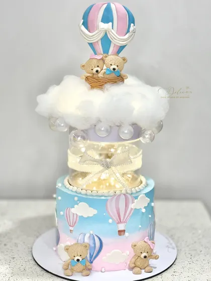 This hot air balloon cake is perfect for a baby shower. It features a transparent separator tier with lights and adorable teddy bears floating on a cotton candy cloud.