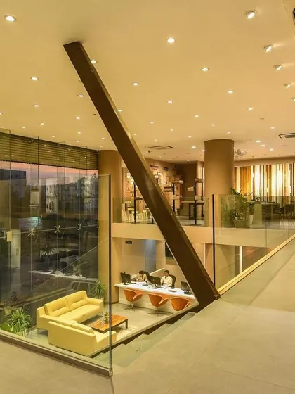 A comprehensive look at a conventional commercial space, highlighting the double-height reception, glass-walled mezzanine, and various product display areas designed for a modern business.