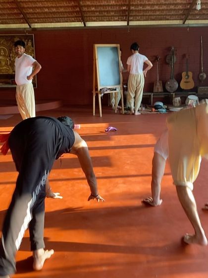 Students practice a variation of a lunge, building strength and stamina. The focus and determination in the room are palpable as everyone moves through the sequence together.