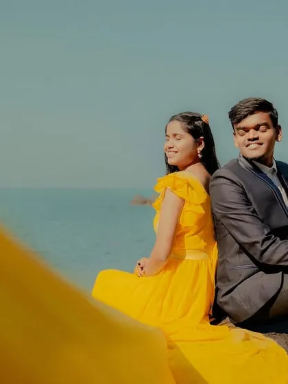 Soaking up the sun and the love. This couple's beachside pre-wedding photo is full of warmth, highlighted by the cheerful yellow gown.