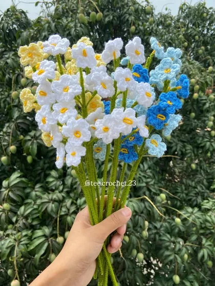 A mixed bouquet of white, yellow, and blue forget-me-nots.