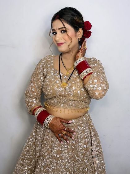A happy and confident look for the wedding festivities. The hair is styled in a beautiful updo with loose curls framing the face.