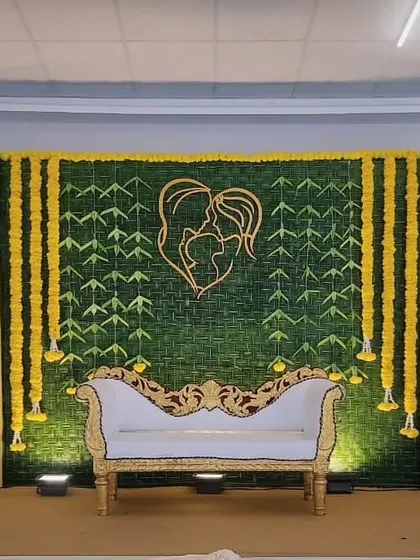 A rustic and natural backdrop made from woven green leaves, with a heart-shaped couple motif in the center, perfect for an engagement or reception.