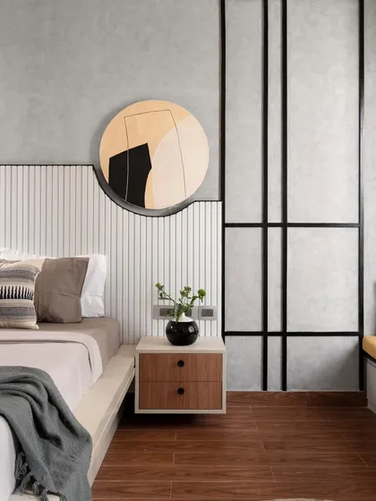 The headboard is the star of this master bedroom. Crafted from white rafters, it features a cutout for a custom canvas artwork that also serves as a subtle light source. The mix of textures and black accents gives the room a sophisticated, modern look.