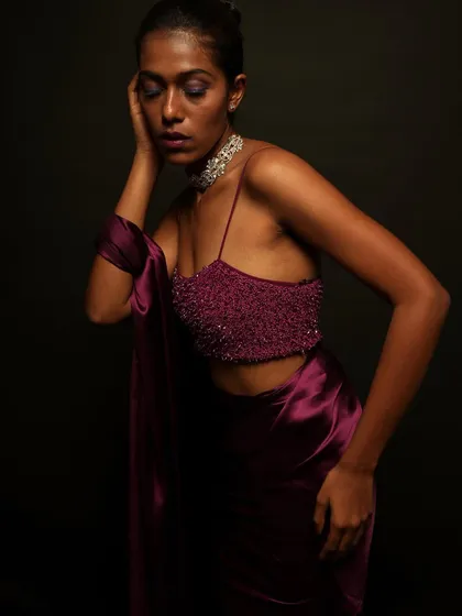 A close up showing the model's expression and the beautiful texture of the beaded top. The makeup is flawless and enhances her features beautifully.