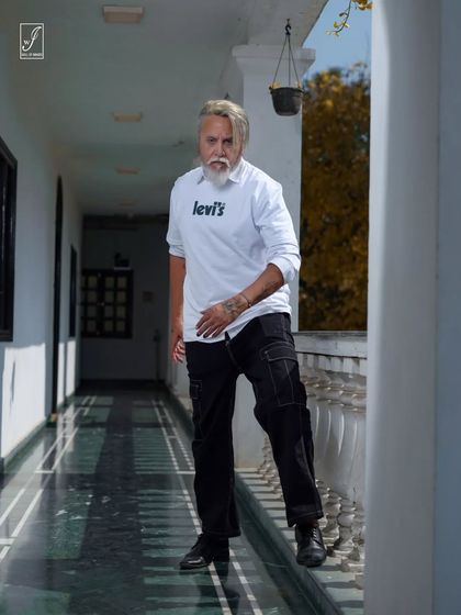 A walking shot in the same location, capturing the model's confident stride and the interplay of light and shadow.