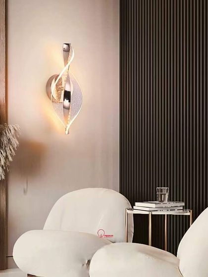 A modern, sculptural wall light with a twisting ribbon of polished chrome and acrylic. This fixture adds a dynamic element to the wall.