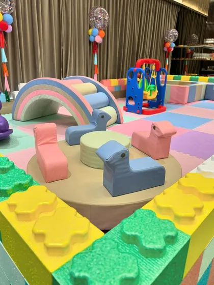 A Central Park-themed first birthday featuring a stunning carousel centerpiece, a candy floss cart, and a large pastel-colored soft play area for endless fun.