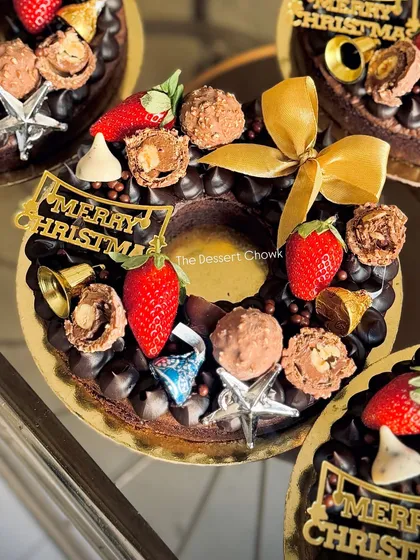 A close-up of the brownie wreath, showing the variety of toppings like Ferrero Rocher, Hershey's Kisses, and fresh strawberries.